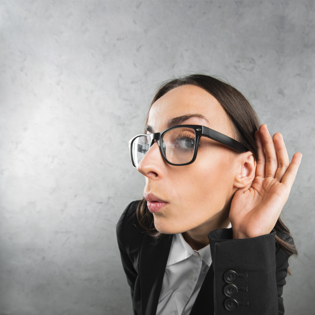 jovem-empresaria-ouvindo-com-a-mao-na-orelha-contra-fundo-cinza_23-2147943856